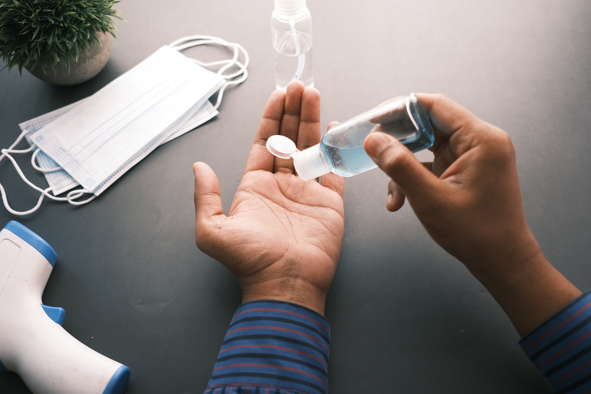 Person Squeezing a Bottle of Sanitizer